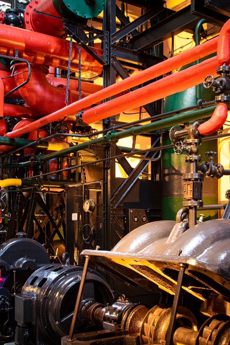 Vibrant industrial machinery with red pipes and complex equipment in a factory.