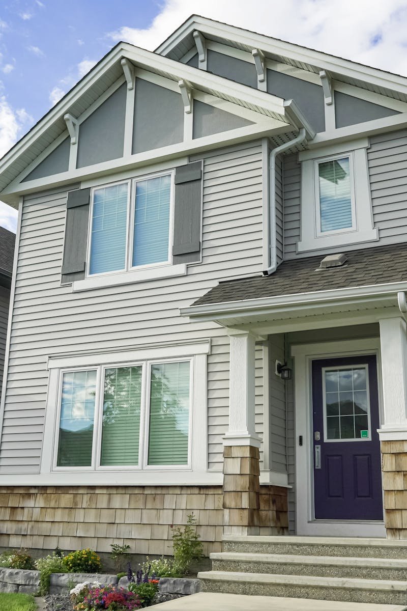 Contemporary suburban home with a front porch and clear blue sky, ideal for real estate themes.